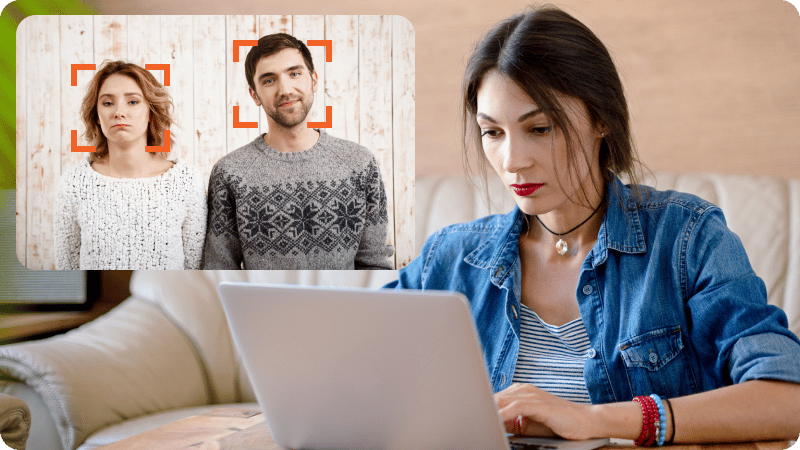 A woman watching a video of two people with made-up facial expressions.