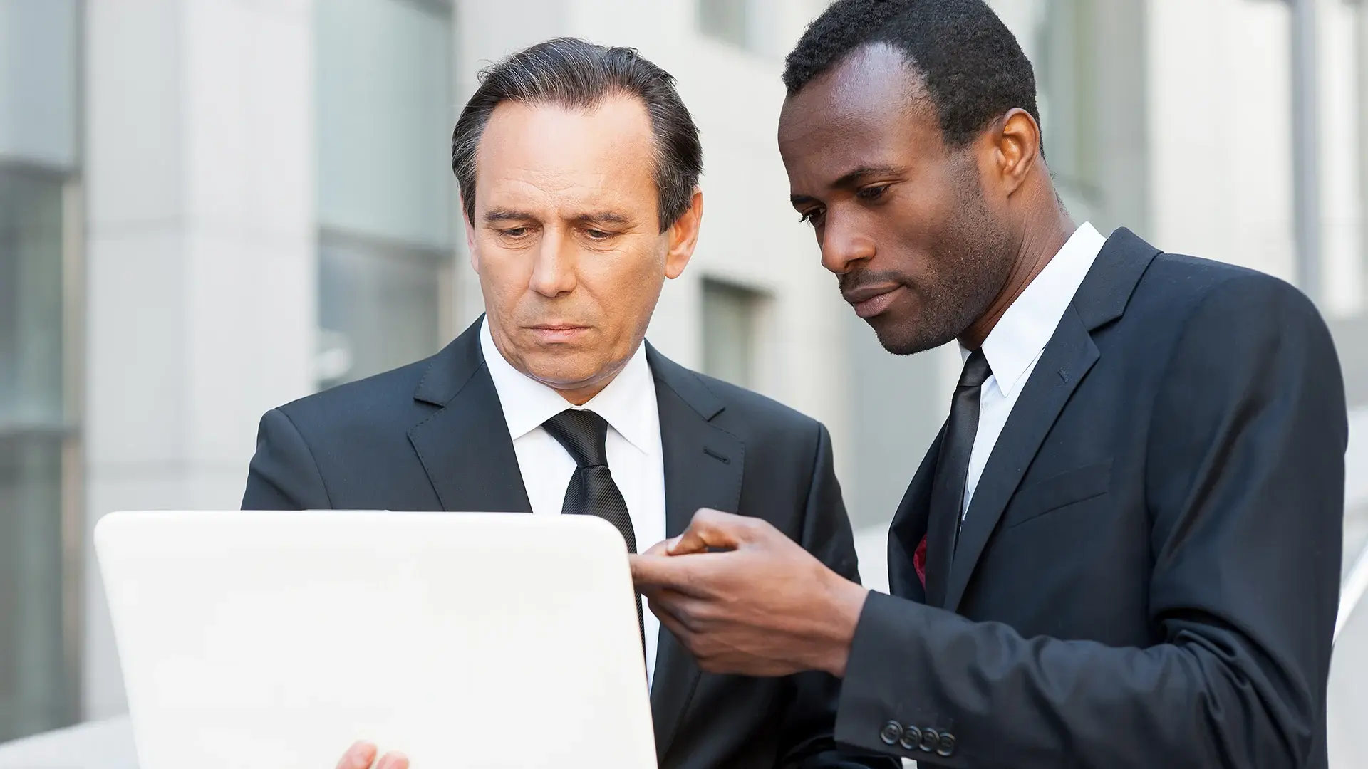 Two lawyer standing and using a laptop 