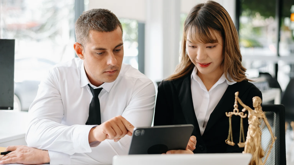 County attorney and legal professional collaborating on digital evidence review using a tablet