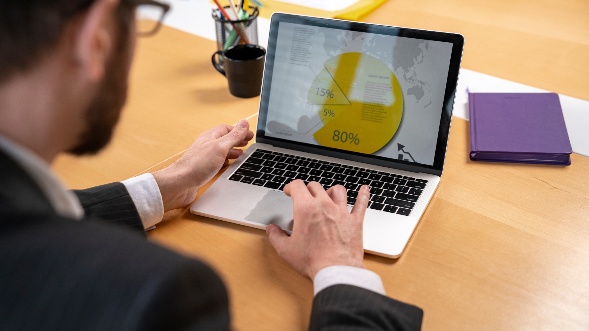 A law firm individual in glasses viewing a laptop screen showing tracking and reporting CLE video training.