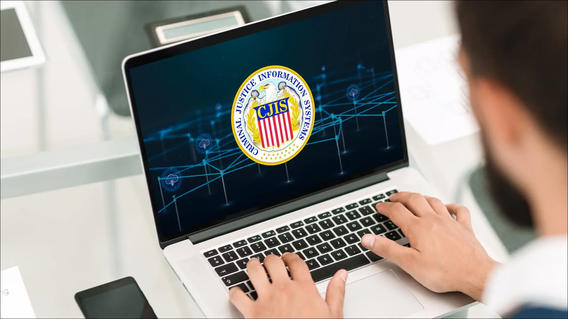 Person using a laptop displaying the CJIS (Criminal Justice Information Systems) security seal