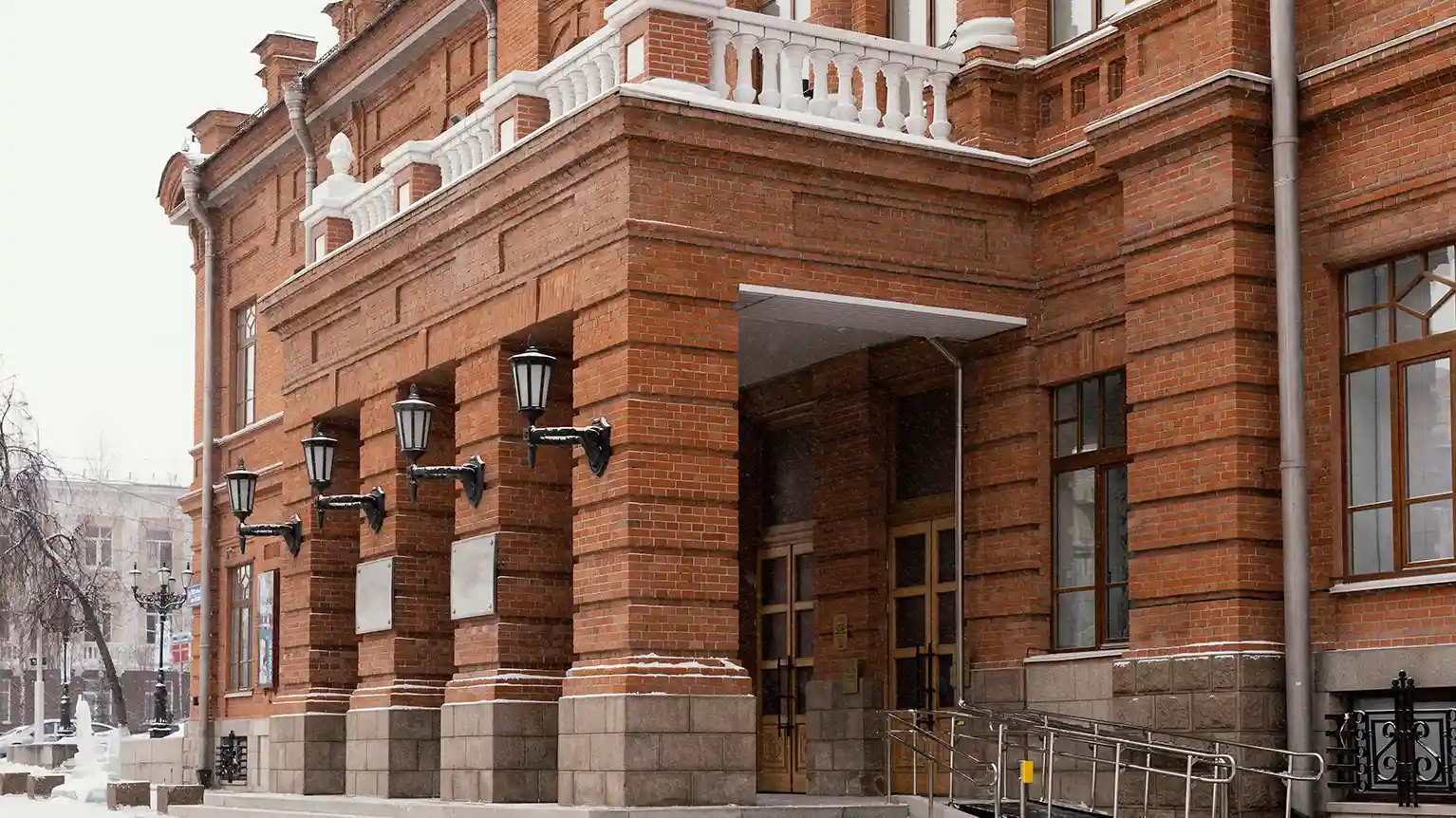 Exterior view of DuPage County Sheriff's Office building in Illinois, showcasing its modern architectural design with large glass panels and brickwork under a clear blue sky