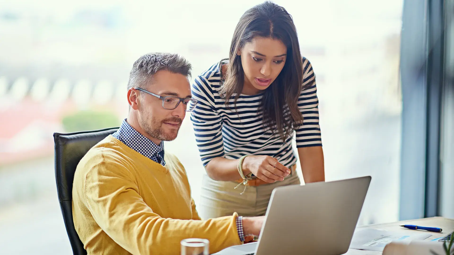 Two colleagues reviewing enterprise AI strategy together on a laptop in an office