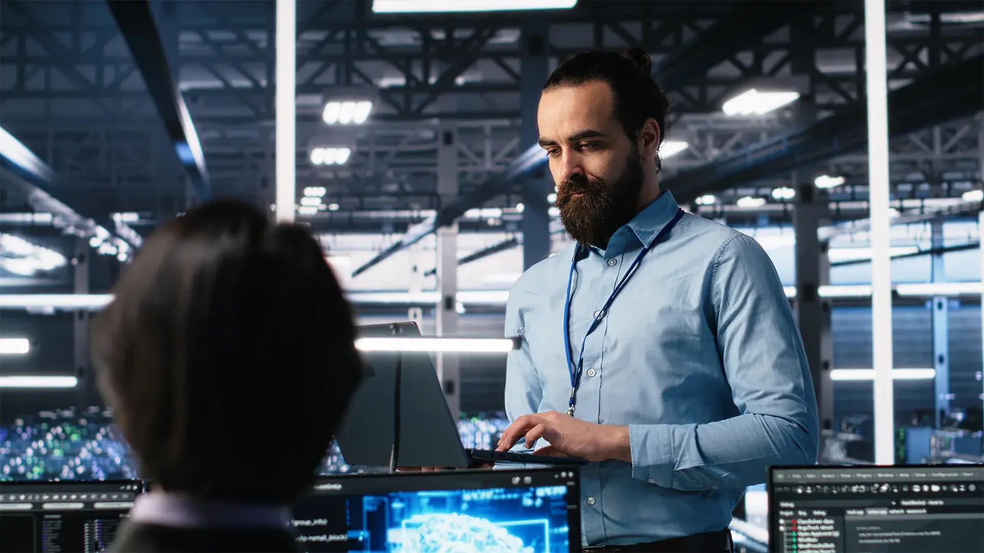 IT professional working on a laptop in a high-tech office.