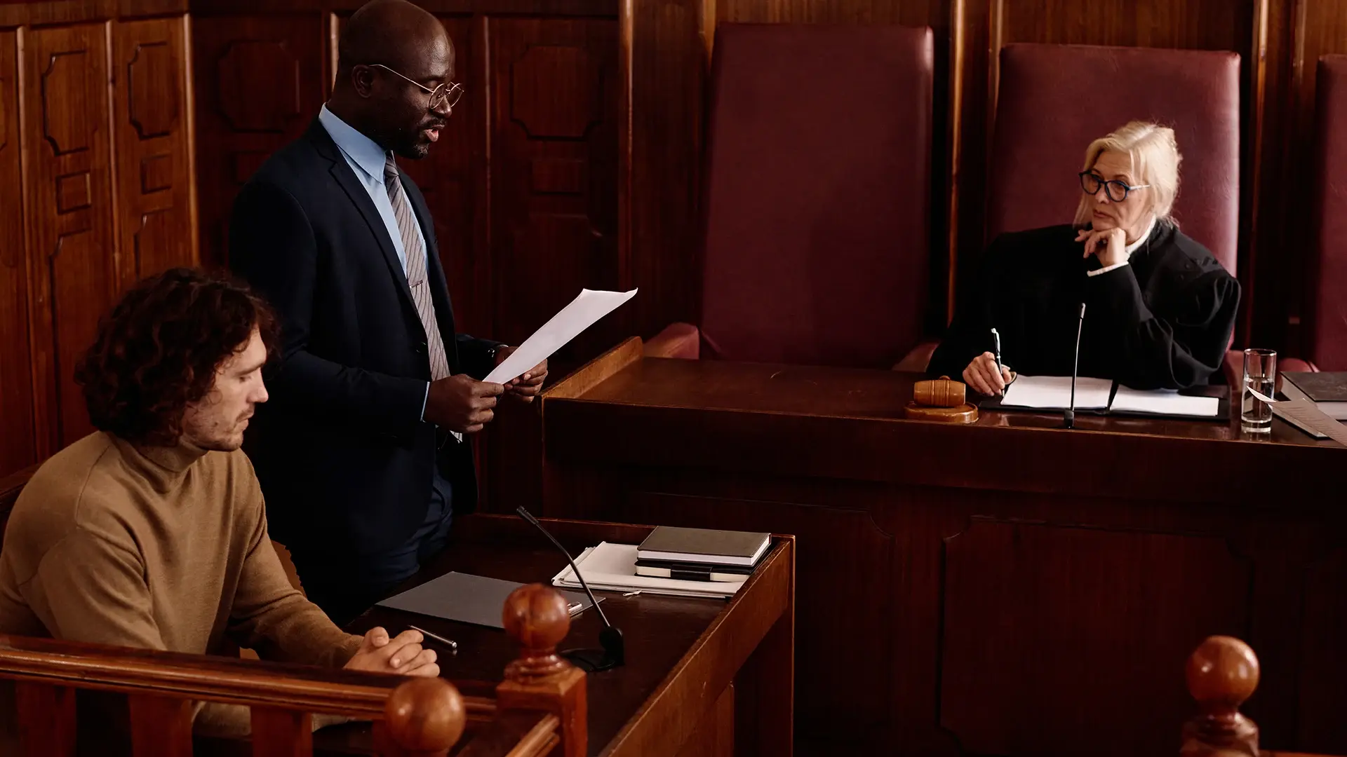 Defendant and attorney standing before a judge in a courtroom.