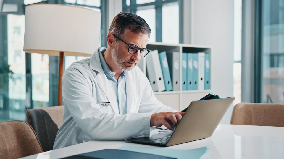 a doctor working on a laptop