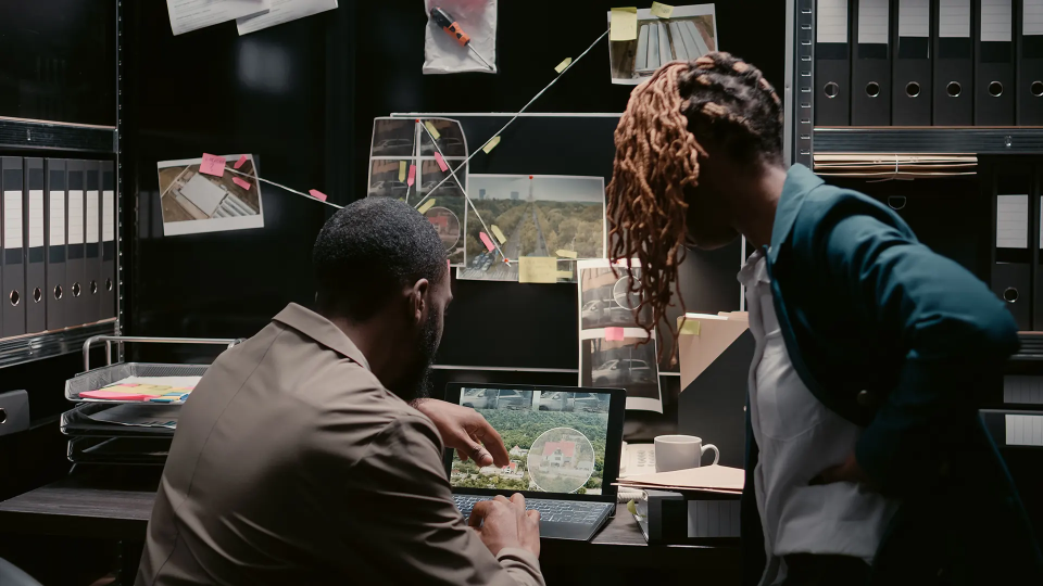 two detectives working on a laptop