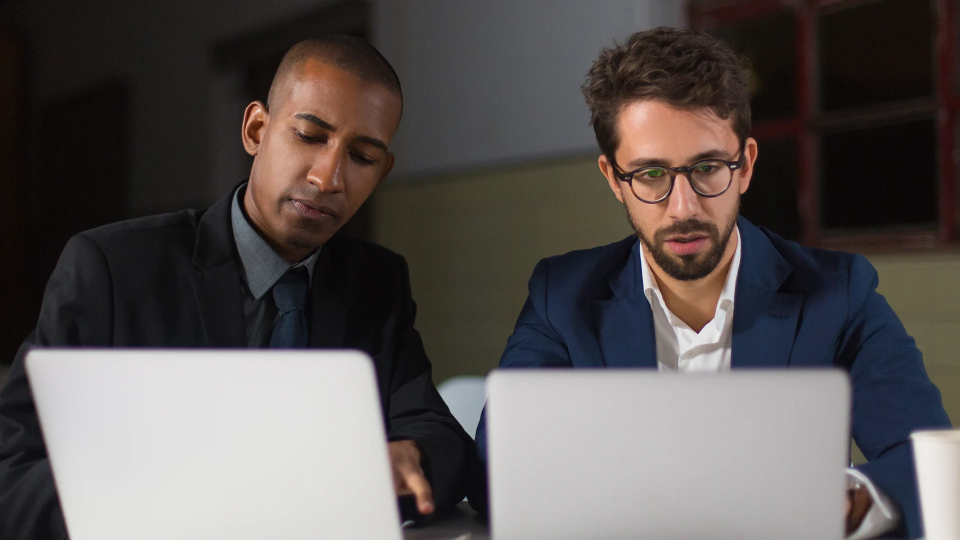 Two persons working on a laptop