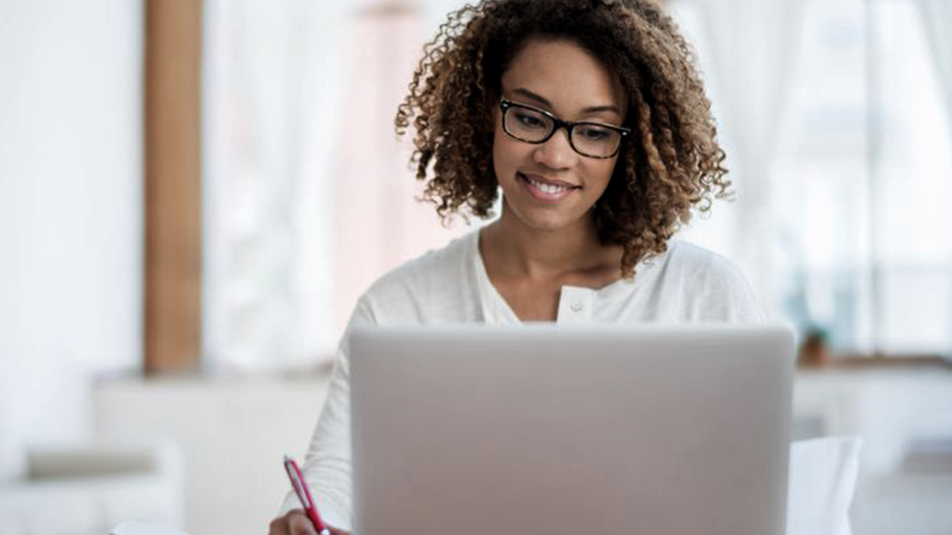 A woman using a laptop to watch videos on a video training platform