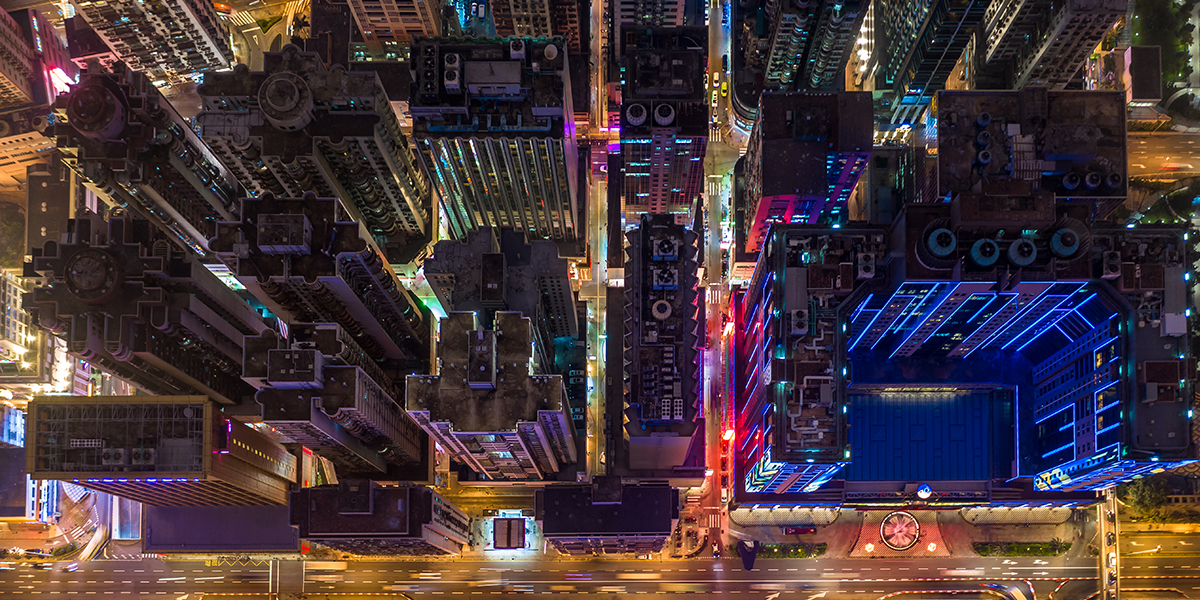 A top down view of a bustling city at night with moving traffic.