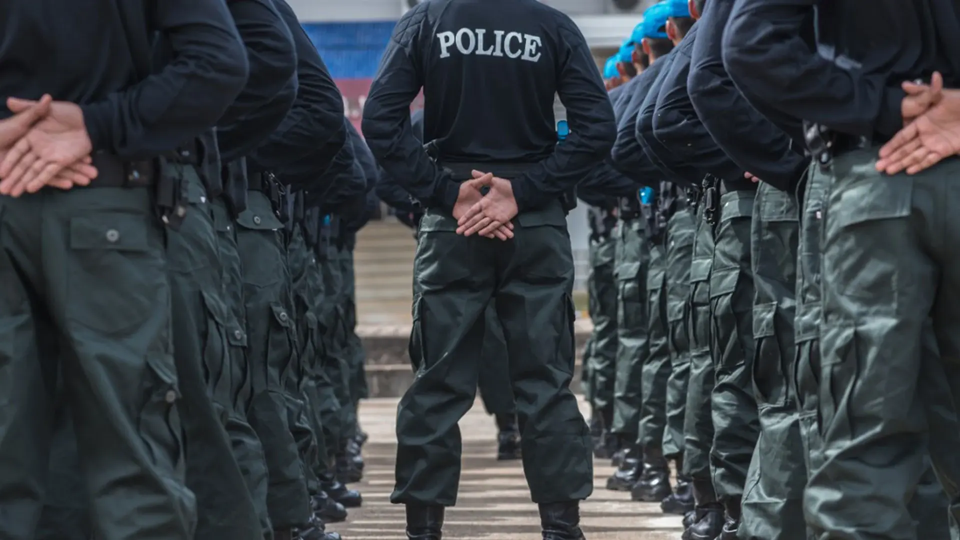 A police officer standing with his hands folded backwards