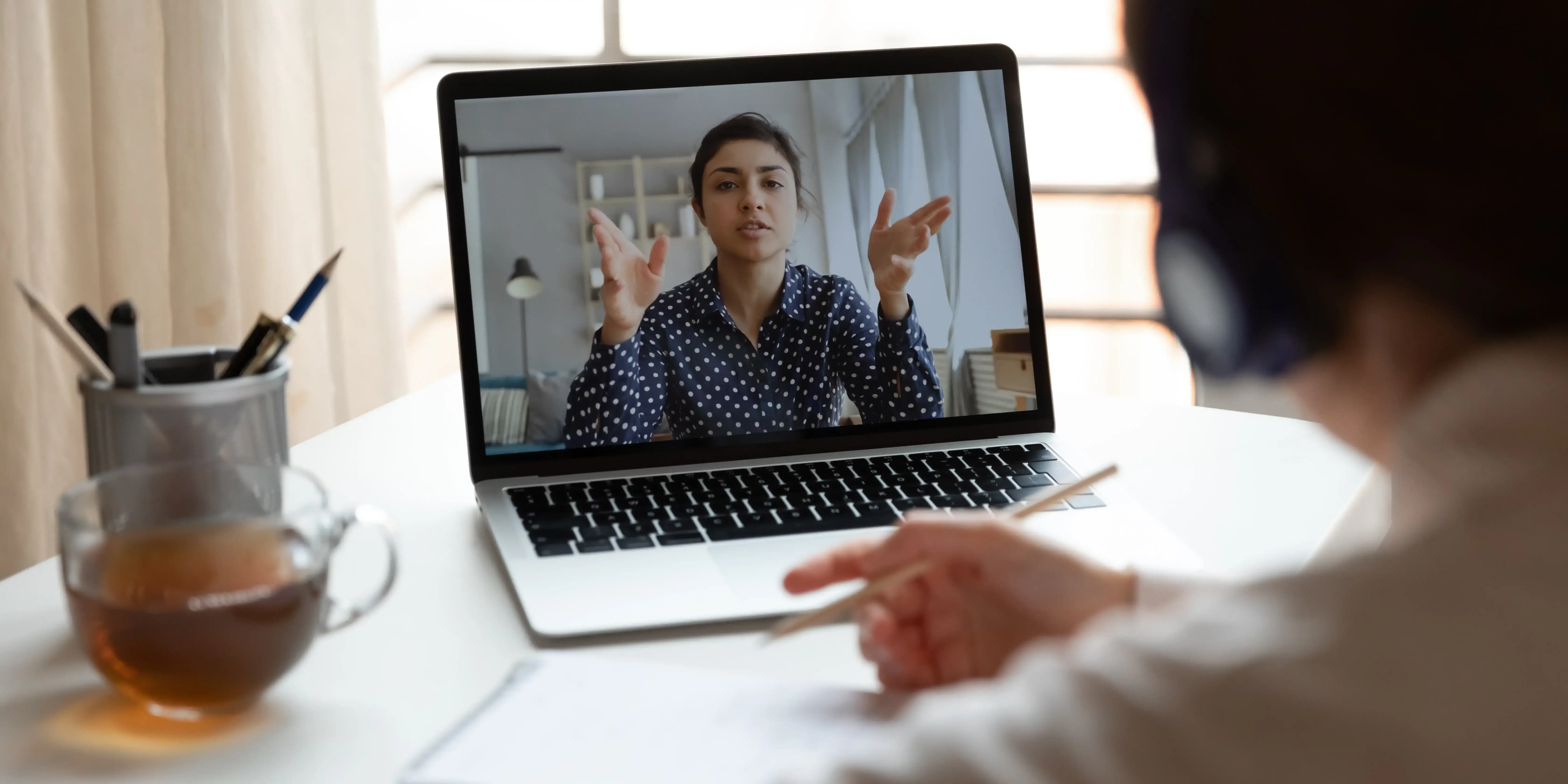 A young man and woman sitting closely together on a couch, smiling while watching a video on a laptop, representing intelligent consumer engagement with a video platform.
