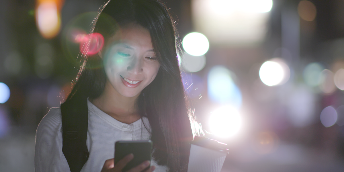 Young woman watching a live stream on her phone