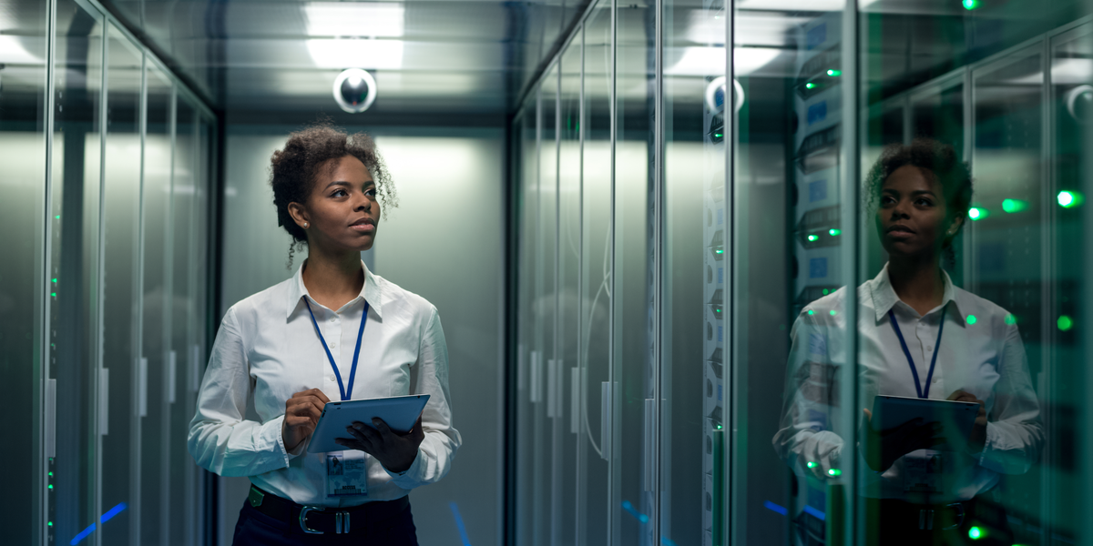 A woman walking in a datacenter with encrypted drives