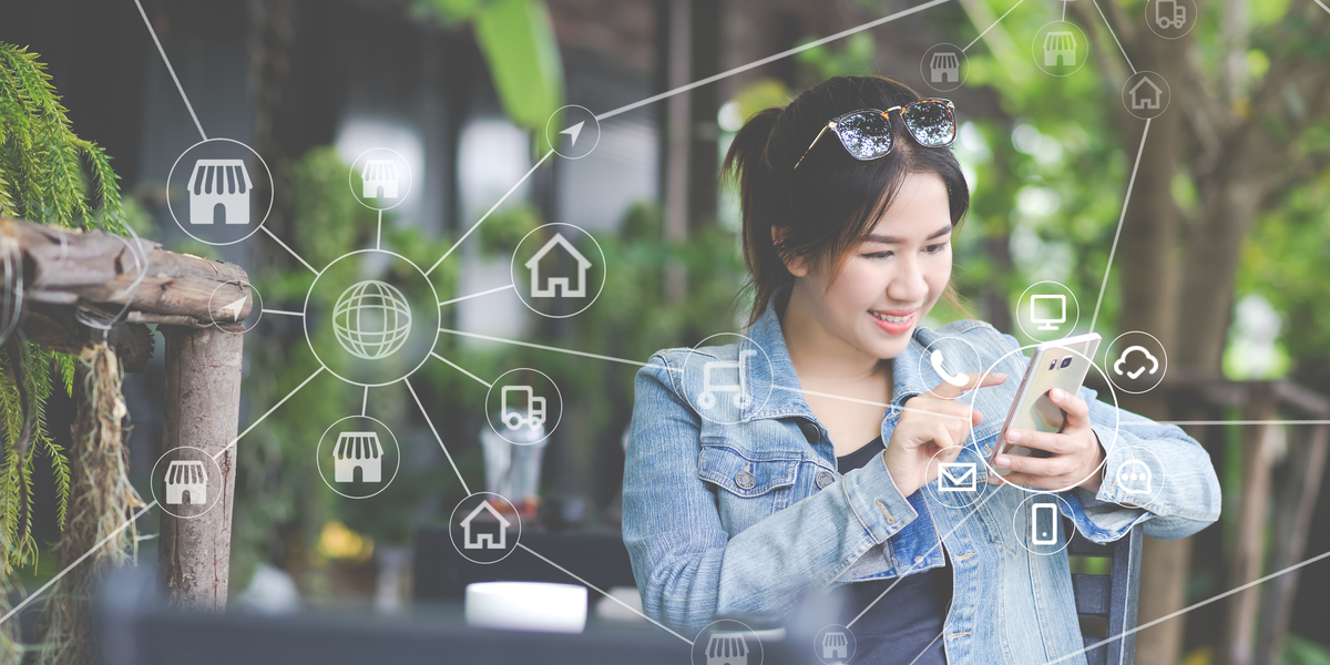 Woman uses smartphone, connecting with various digital network services.